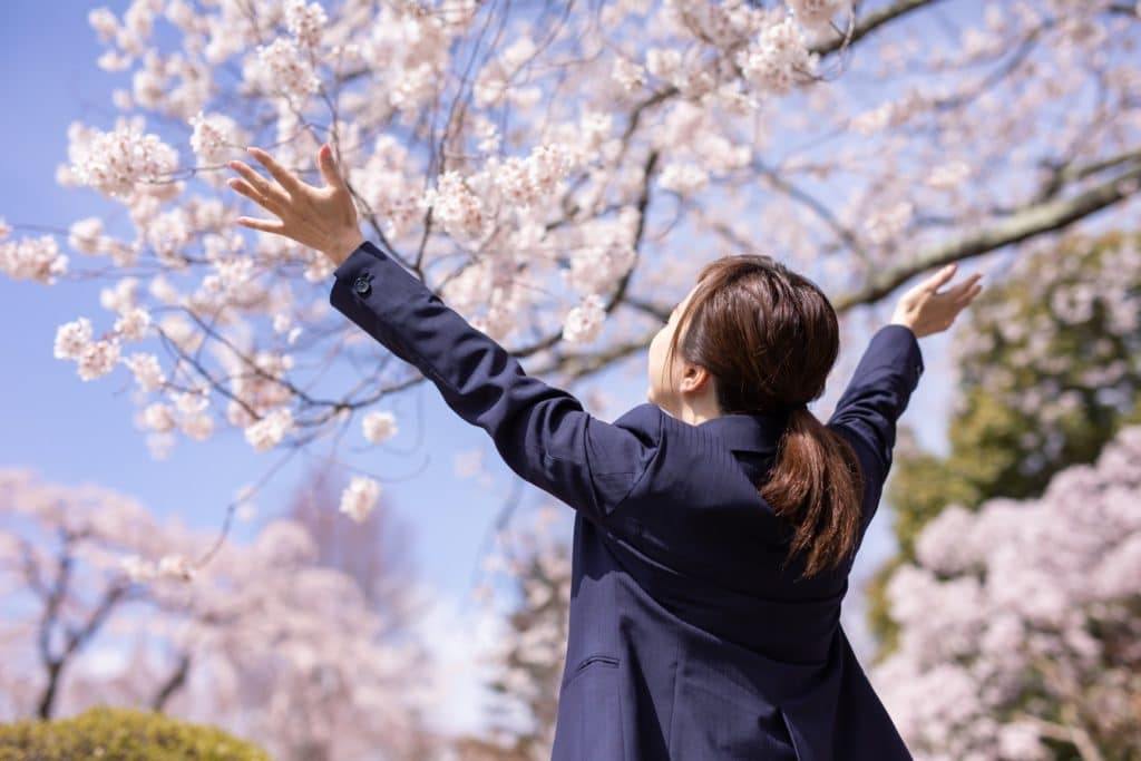 桜の木とスーツの女性