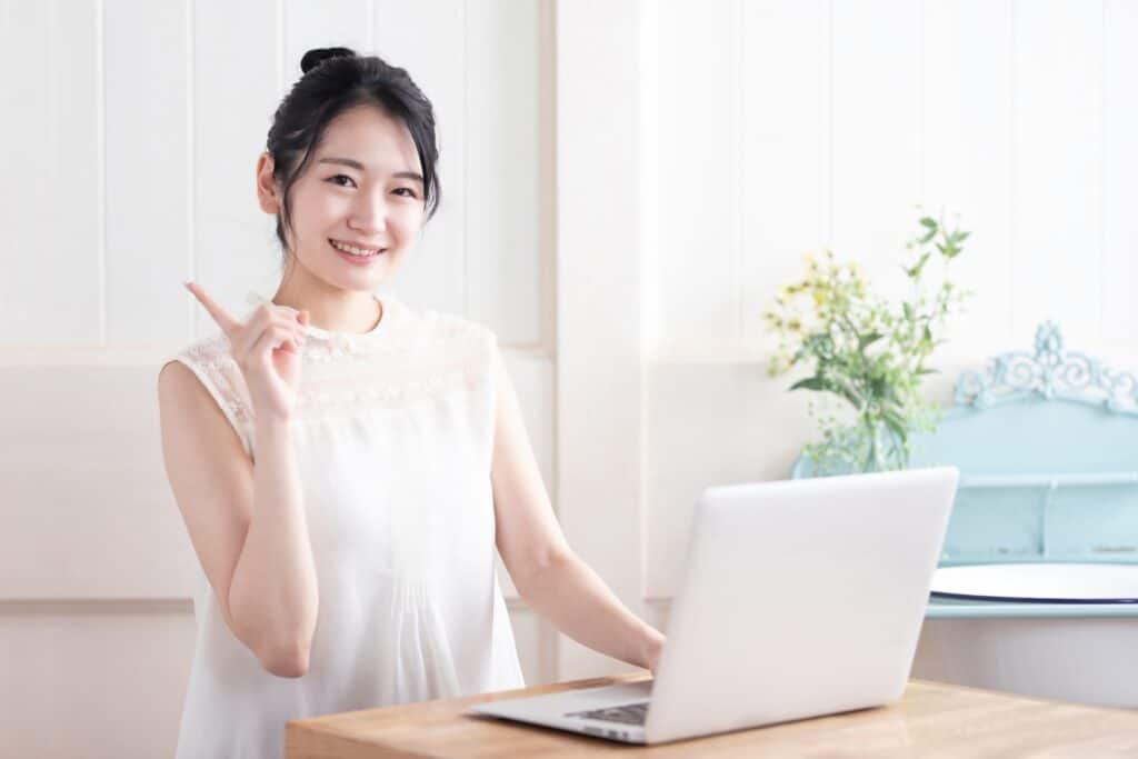 人差し指を立てる女性、ノートパソコン